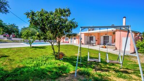 A residential property with a grassy yard, a swing set, and a pool. - Villazia Exclusive Estate (Corfu)