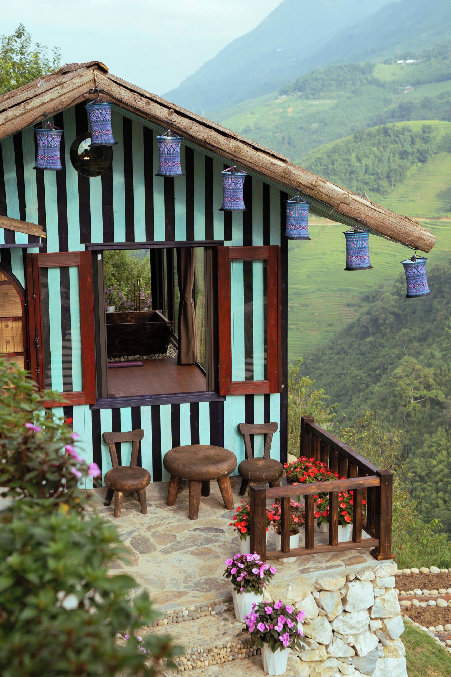 Un chalet rustique doté d’un escalier en pierre, de meubles en bois et de lanternes suspendues.