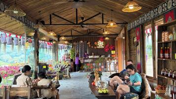 A restaurant with a wooden ceiling, tables, and chairs, and a view of the outdoors.