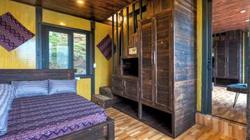 Une chambre avec un grand lit, une armoire intégrée et une vue sur l’extérieur grâce à une porte vitrée.