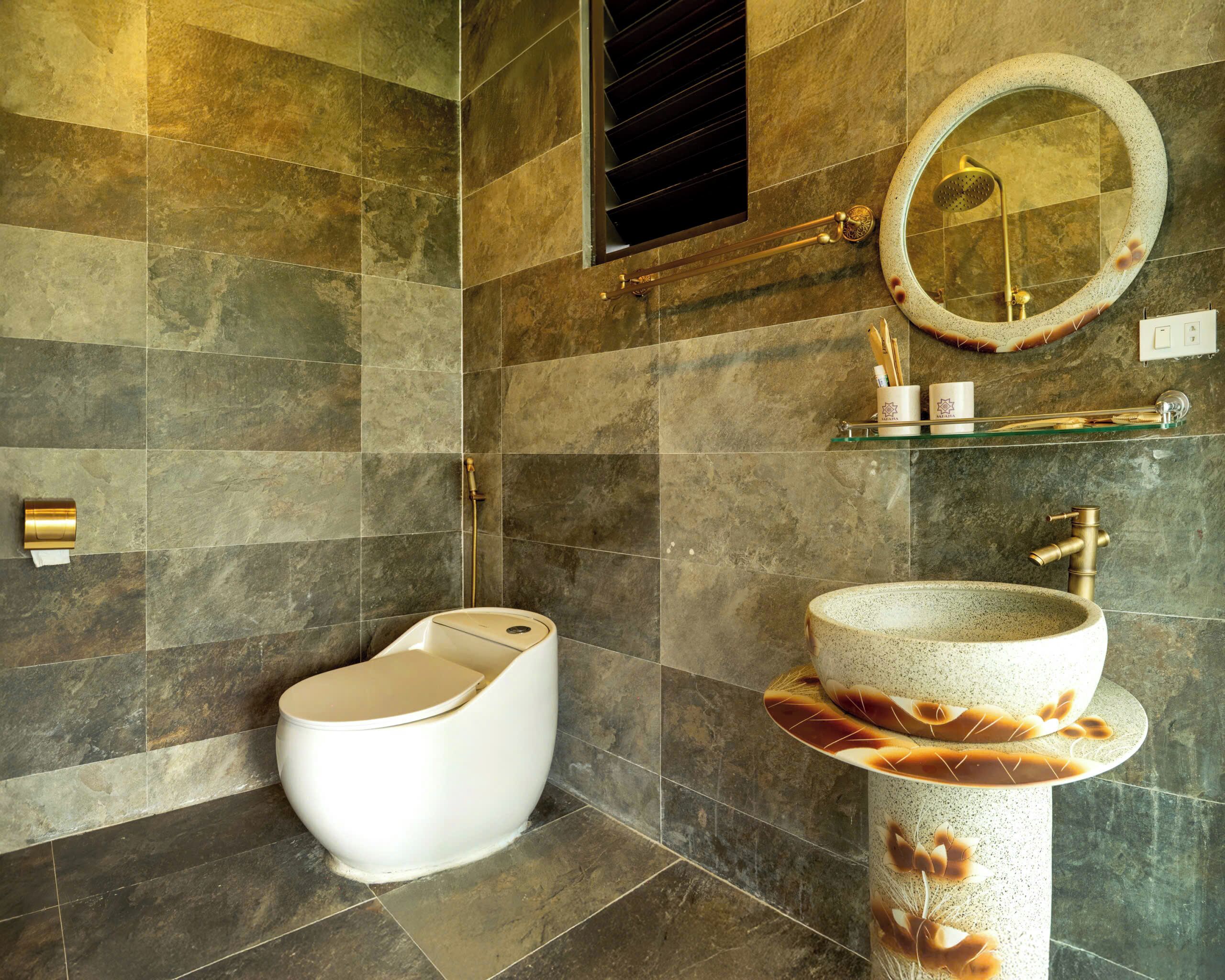 A modern bathroom with a toilet, a sink with a decorative basin, a mirror, and a shower area.