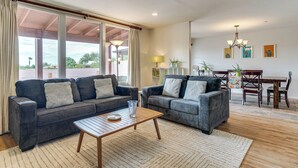 A spacious living room with two grey sofas, a wooden coffee table, and a dining area with a wooden table and chairs. - Mtn-View Townhome w/ Pools: 5 Mi to Sabino Canyon! (Tucson)