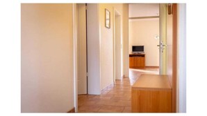 A hallway with a wooden bench, a television, and a door leading to a room. - Suurhusen - Greetsiel (Greetsiel)
