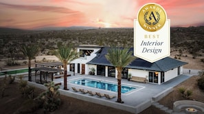 A modern house with a pool, solar panels, and a desert landscape. - Iconic 6BR Desert Retreat w/ Pool, Pickleball & Fire Pit Joshua Tree Mansion by Avantstay (Joshua Tree)