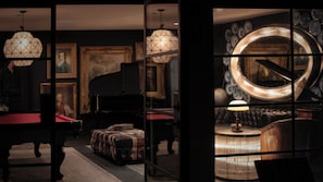 A room with a pool table, a piano, a sofa, and a large mirror with a circular frame. - Iconic 6BR Desert Retreat w/ Pool, Pickleball & Fire Pit Joshua Tree Mansion by Avantstay (Joshua Tree)