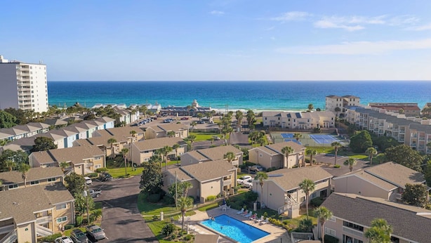 A coastal resort with multiple-story buildings, a swimming pool, and a view of the ocean. - Steps From the Sand Bright Coastal Stay w/ Pool Access Coastal Hideaway by Avantstay (Destin)
