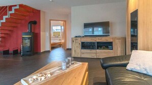 Een moderne woonkamer met een open haard, een televisie en een houten salontafel.