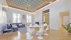 Un salon moderne avec un coin repas, un lustre et une enseigne sur laquelle on peut lire « NATURALISTA ».