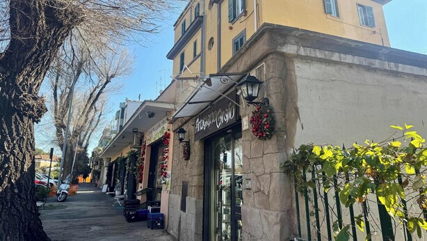 Una vista di strada che mostra un edificio con un negozio chiamato 'Artisan's Corner'.