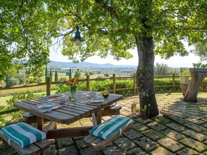 Un juego de mesa de picnic de madera al aire libre, con vistas al campo.