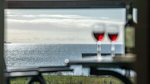Visão pela janela com reflexo de um navio e uma ponte.