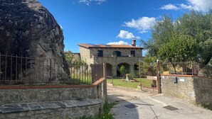 A stone building with a tiled roof, a stone pathway, and a large rock. - Stone House Gebel el Son (Novi Velia)