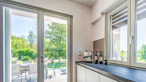 A modern kitchen with a sliding glass door leading to an outdoor dining area. - Stunning private villa for 8 guests with hot tub, WIFI, A/C, TV, terrace and panoramic view (Camerano)