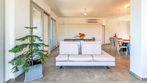 A modern living area with a sofa, a dining table, and a potted plant. - Stunning private villa for 8 guests with hot tub, WIFI, A/C, TV, terrace and panoramic view (Camerano)