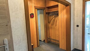 Een houten kast met een metalen rek en een deur met slot.