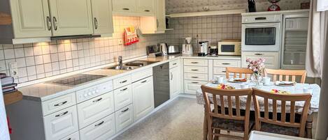 Mikrobølgeovn, ovn, oppvaskmaskin og høy barnestol