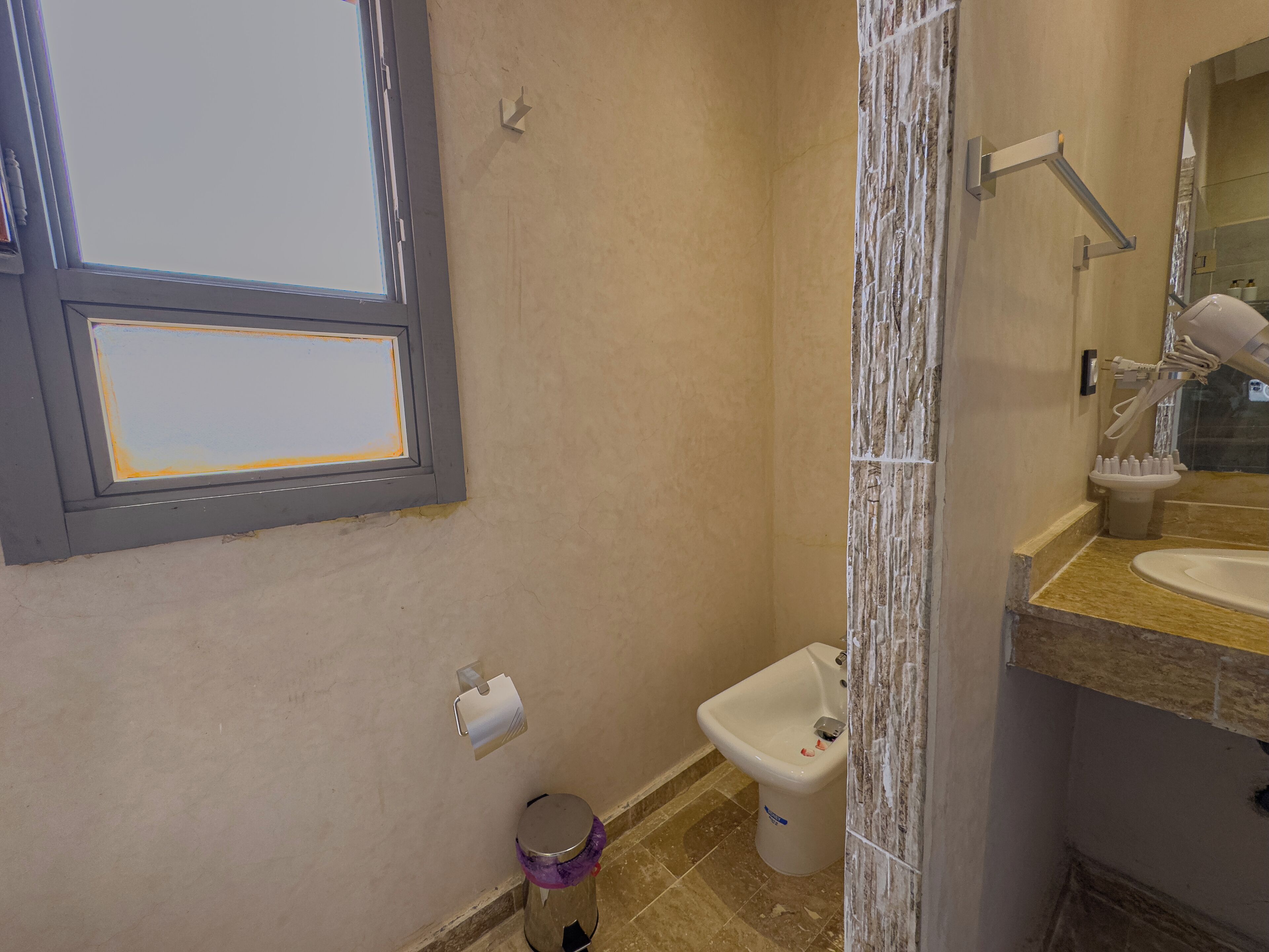 A bathroom with a toilet, bidet, and sink.