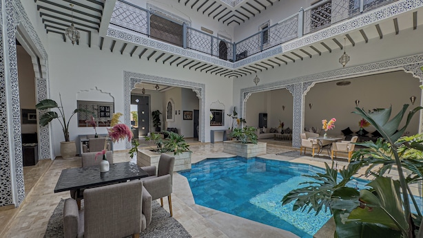 A spacious indoor pool area with a high ceiling and intricate white lattice work. - Riad Tonaroz Gold (Marrakech)
