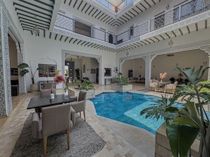 A spacious indoor pool area with a high ceiling and intricate white lattice work. - Riad Shiny Moon (Marrakech)