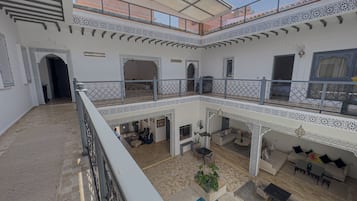 Un intérieur à plusieurs niveaux, doté d’une cour centrale, de balcons et de détails architecturaux raffinés.