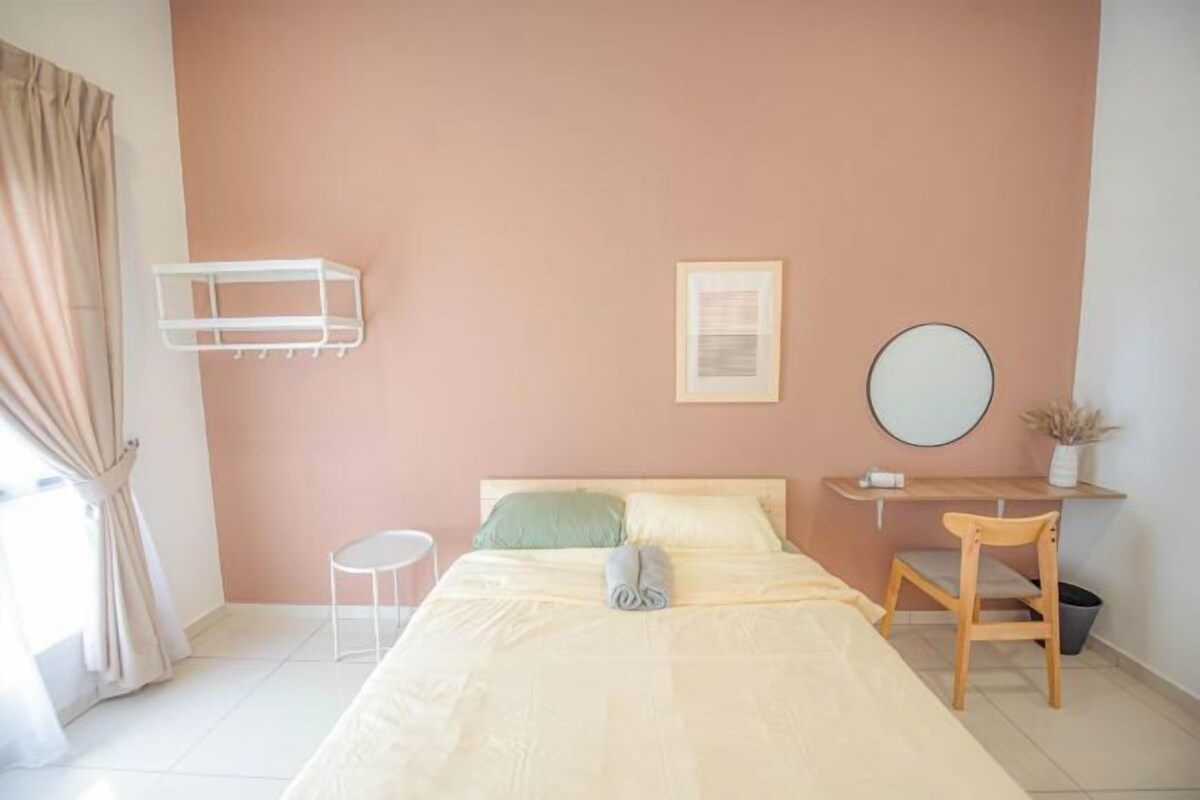 Un dormitorio con cama, mesita de noche, silla y un taburete pequeño.