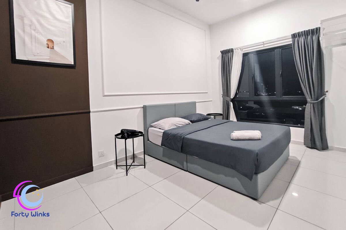A modern bedroom with a bed, a nightstand, a ceiling fan, a window with curtains, and a city view.