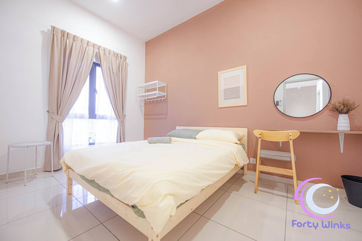 A bedroom with a bed, a chair, a shelf, a mirror, and a window with curtains.
