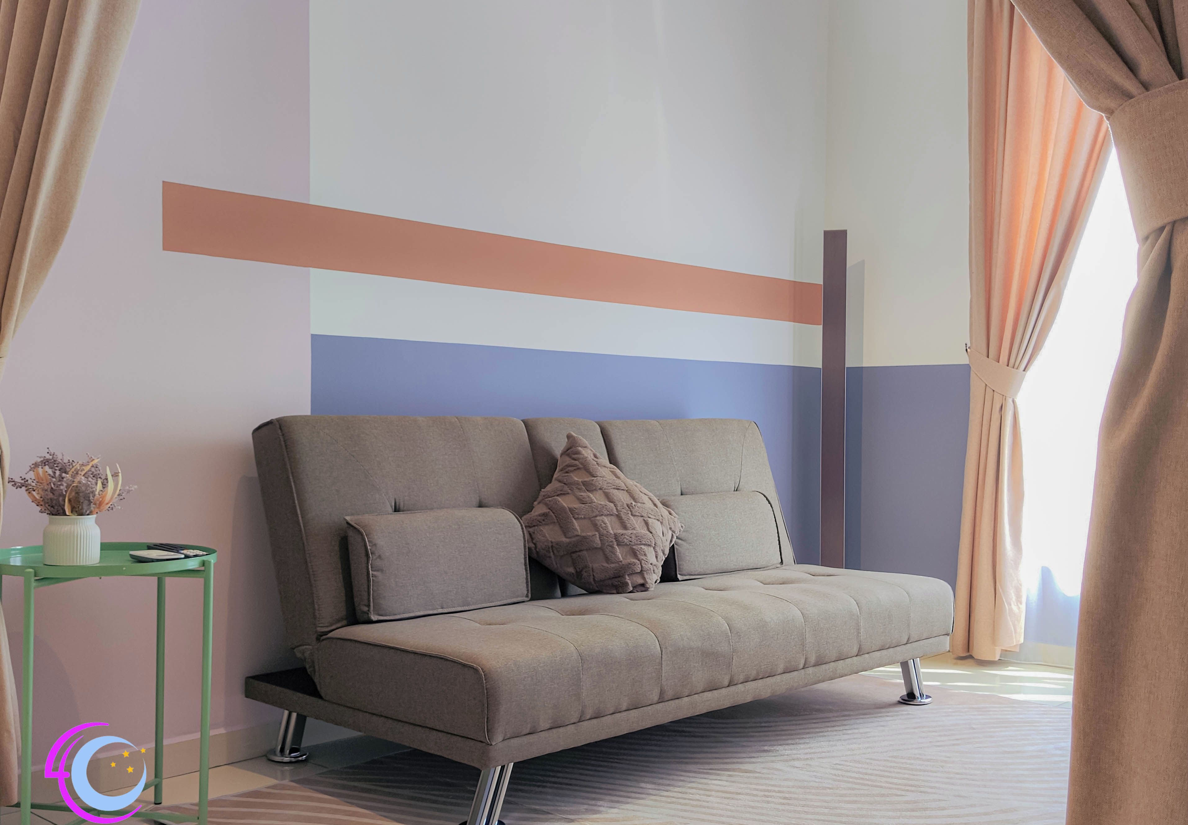 A modern living room with a sofa, a small side table, and a decorative plant.