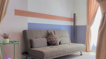 A modern living room with a sofa, a small side table, and a decorative plant.