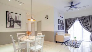 Una sala de estar moderna con comedor, ventilador de techo y un amplio ventanal con cortinas.