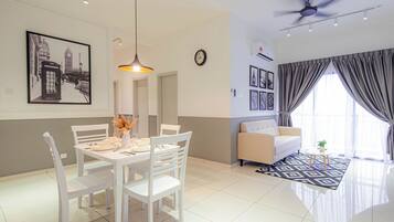 A modern living room with a dining area, a ceiling fan, and a large window with curtains.