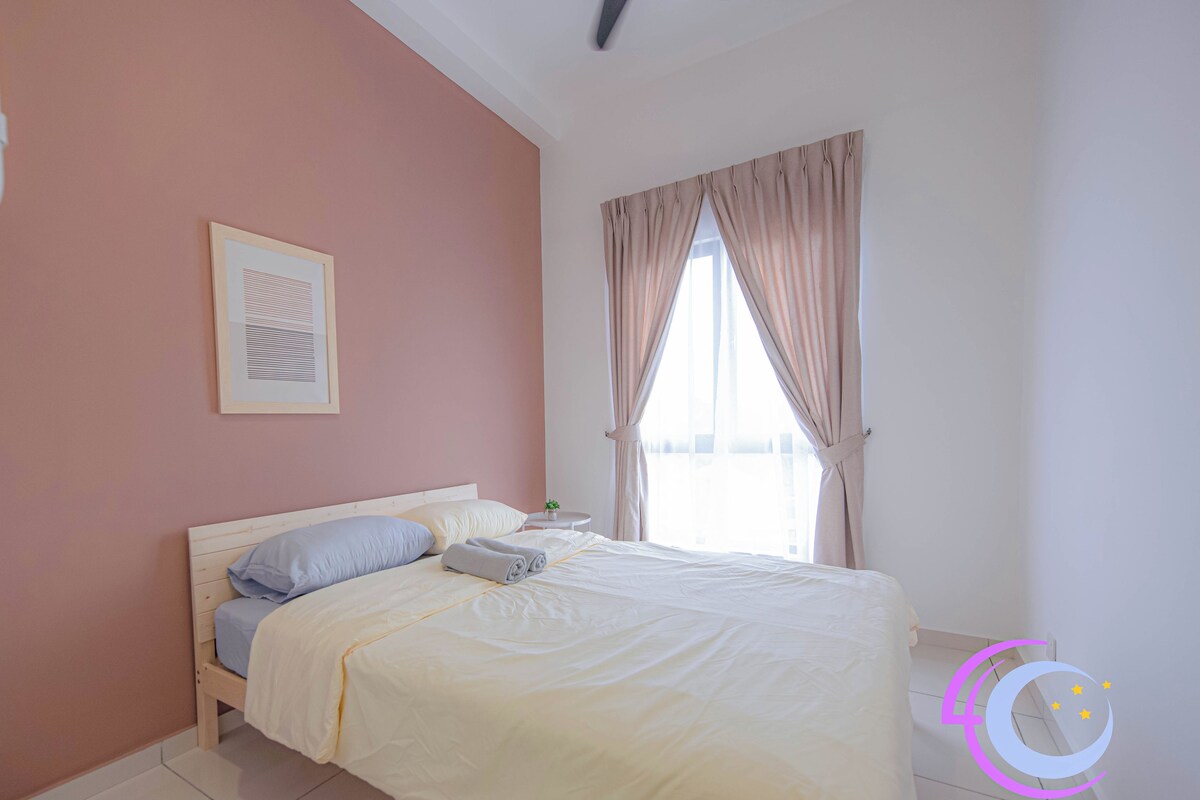 Un dormitorio con una cama, un cuadro en la pared, una ventana con cortinas y una mesita con una planta.