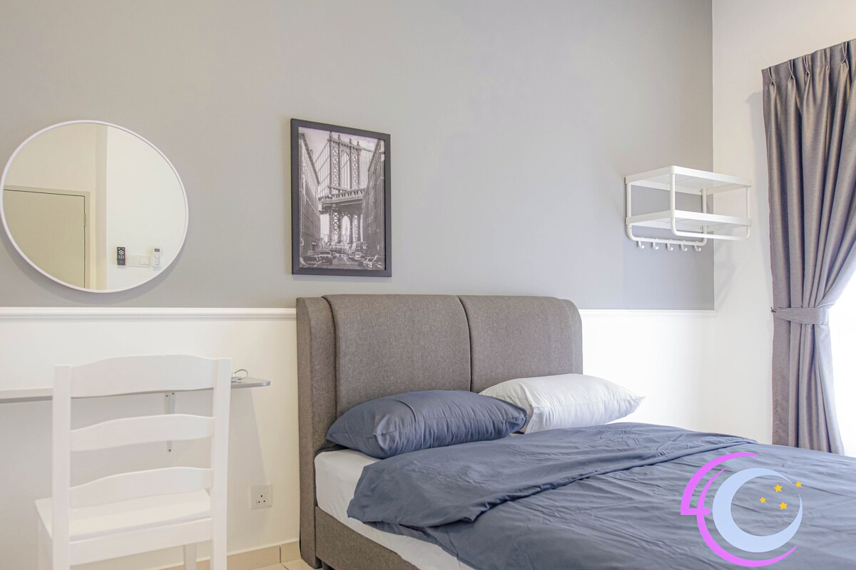 Un dormitorio moderno con una cama gris, una silla blanca y un cuadro en la pared.