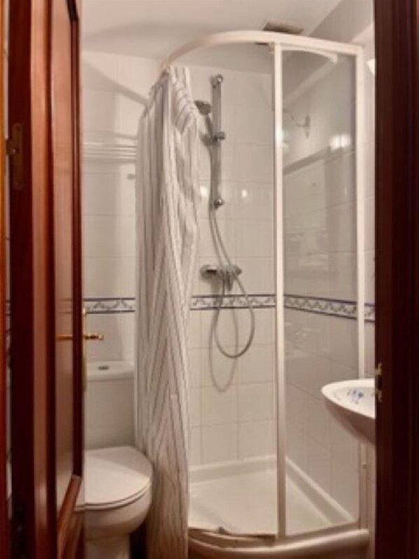 Ein Badezimmer mit Dusche, Toilette und Waschbecken.
