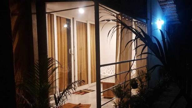 A well-lit entrance with a glass partition, a door, and a staircase leading inside. - Casa Fiesta (Canacona)
