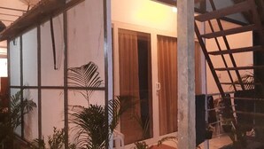 A room with a large window, a wooden staircase, and a door leading to another room. - Casa Fiesta (Canacona)