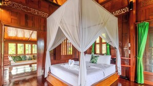A room with a four-poster bed, wooden walls, and a bench with cushions. - 6BR Villa Huge Pool & Mountain View V89 (Rawai)