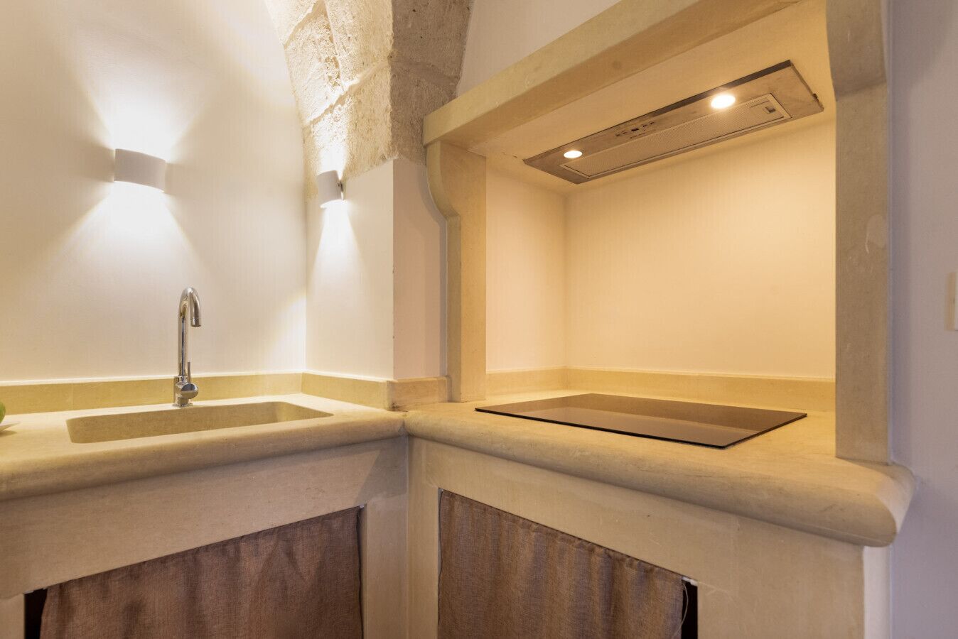 Un bagno con lavandino, specchio e una lampada a soffitto.