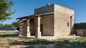 A stone building with a simple rectangular structure, a covered porch, and a small door. - Dimora Forticito - Marittima di Diso (Marittima)