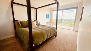 A four-poster bed with a view of the outdoors through a sliding glass door. - Matakana View- Treetop retreat in Matakana (Whangaripo)
