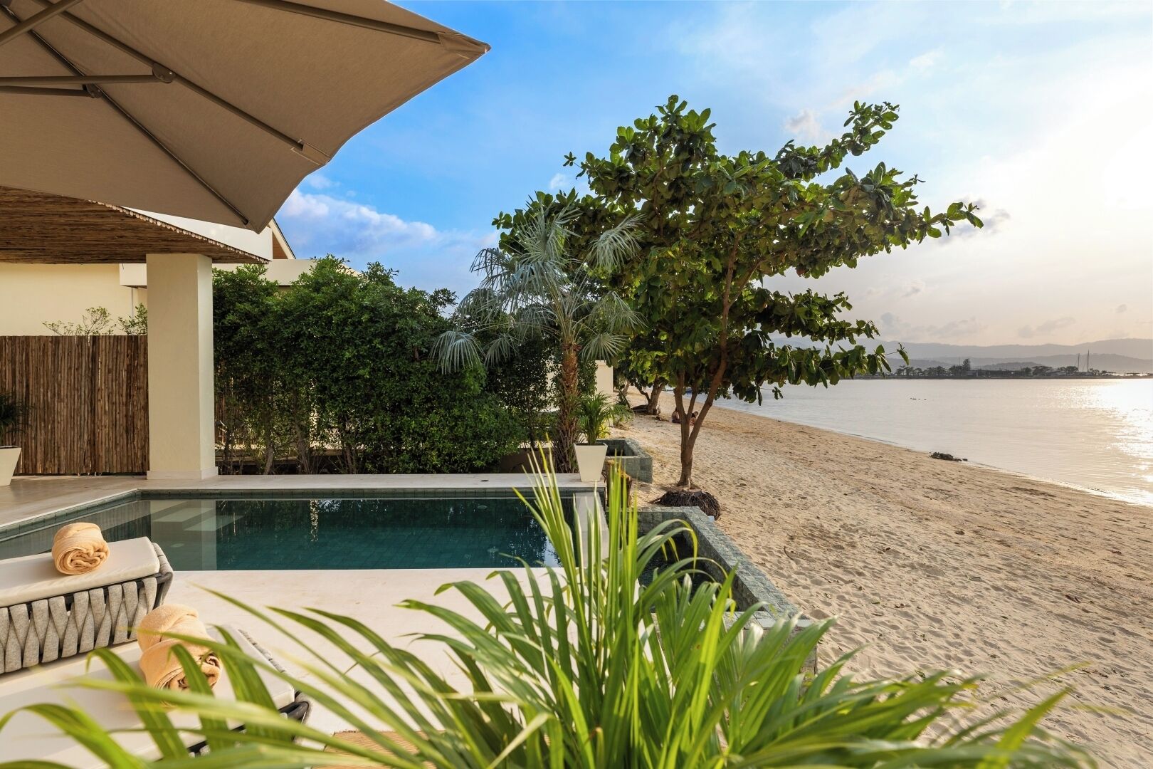 Un espace aménagé au bord de la piscine, offrant une vue sur la plage et l’océan.