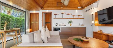 A modern interior with a wooden ceiling, a sofa, a dining table, and a kitchen area.