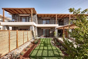 A two-story house with a stone facade, wooden balconies, and a well-maintained garden.