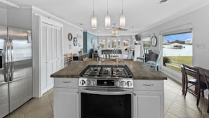 Egy modern konyha rozsdamentes acélból készült berendezésekkel, központi szigettel és kilátással egy tóra.