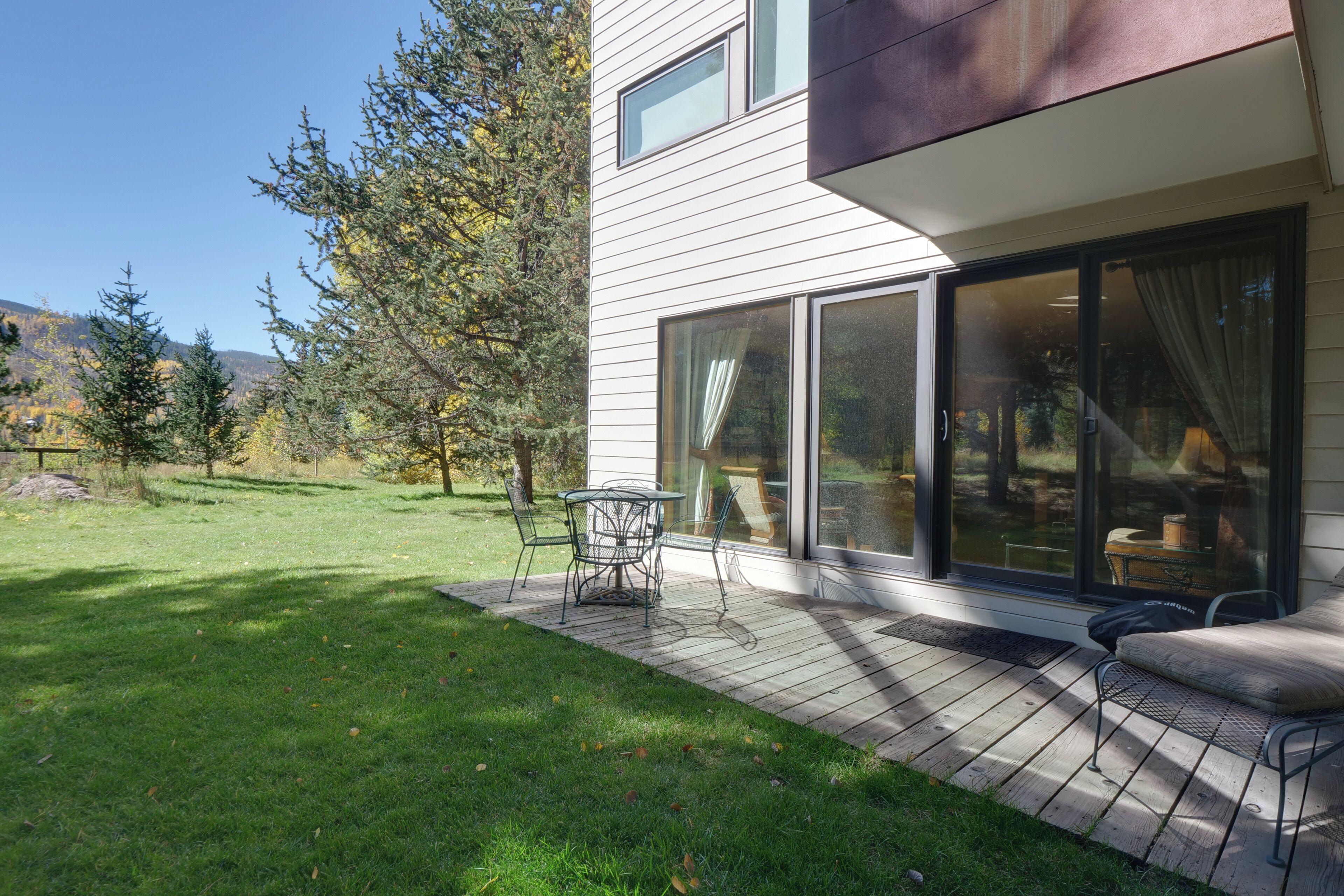 Une maison moderne dotée d’une terrasse, d’un coin repas et d’une grande porte-fenêtre coulissante.