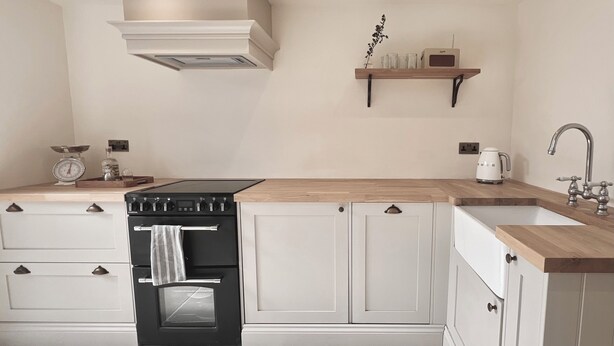 A modern kitchen with a built-in oven, a sink, and a wooden countertop. - Cosy cottage in the heart of Stow-on-the-Wold, pet-friendly (Stow-on-the-Wold)