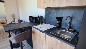 Una cocina moderna con armarios de madera, encimera negra y un lavabo integrado.