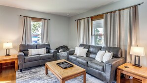 Un salon avec deux canapés en cuir, une table basse en bois et un tapis.