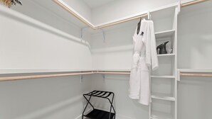 Un dressing avec une tringle à vêtements, des étagères et un porte-chaussures.