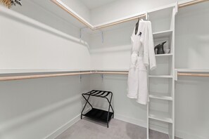 Un vestidor con una barra para colgar, estantes y un zapatero.